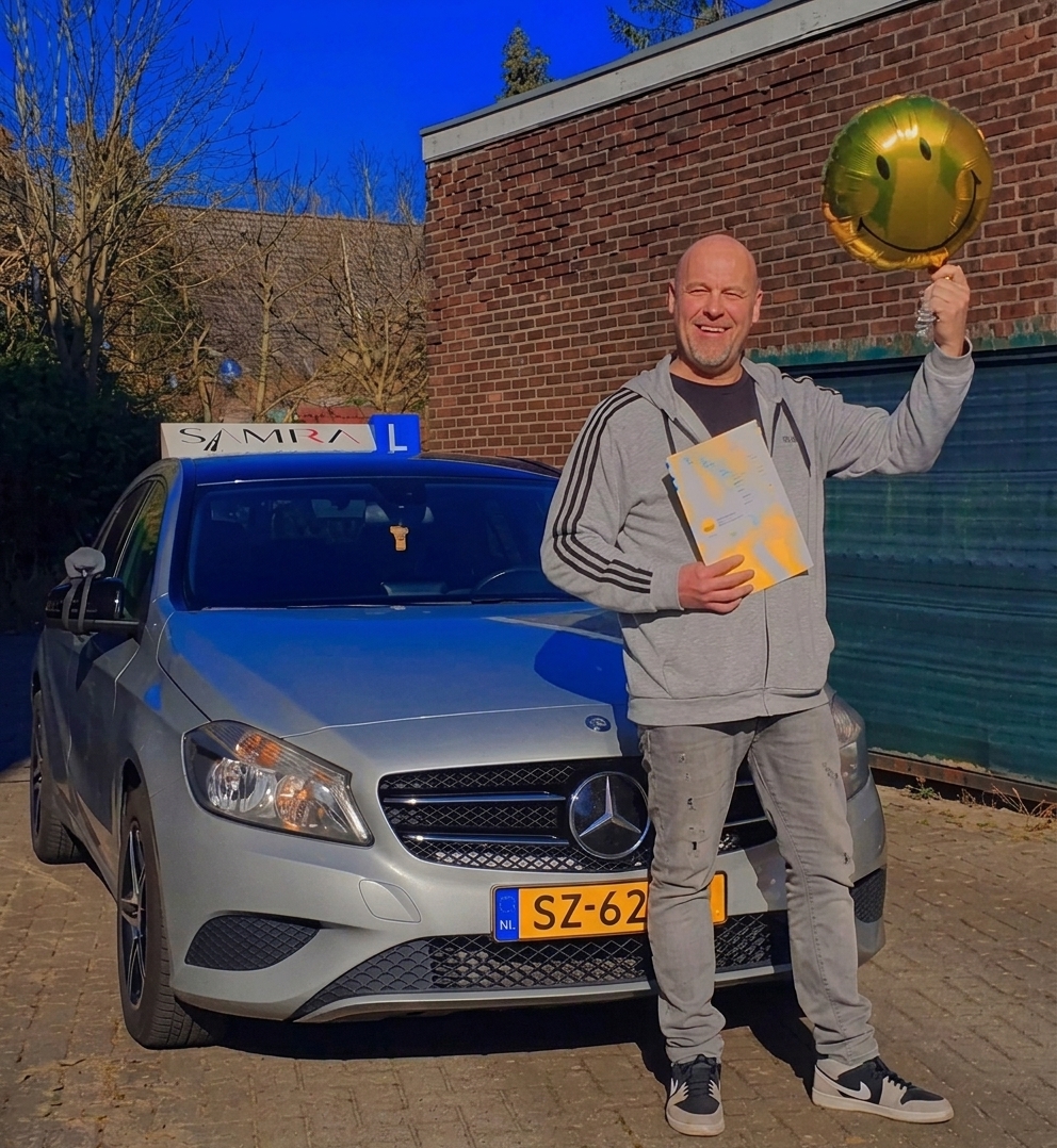 Rijinstructeur Sjaak bij de lesauto